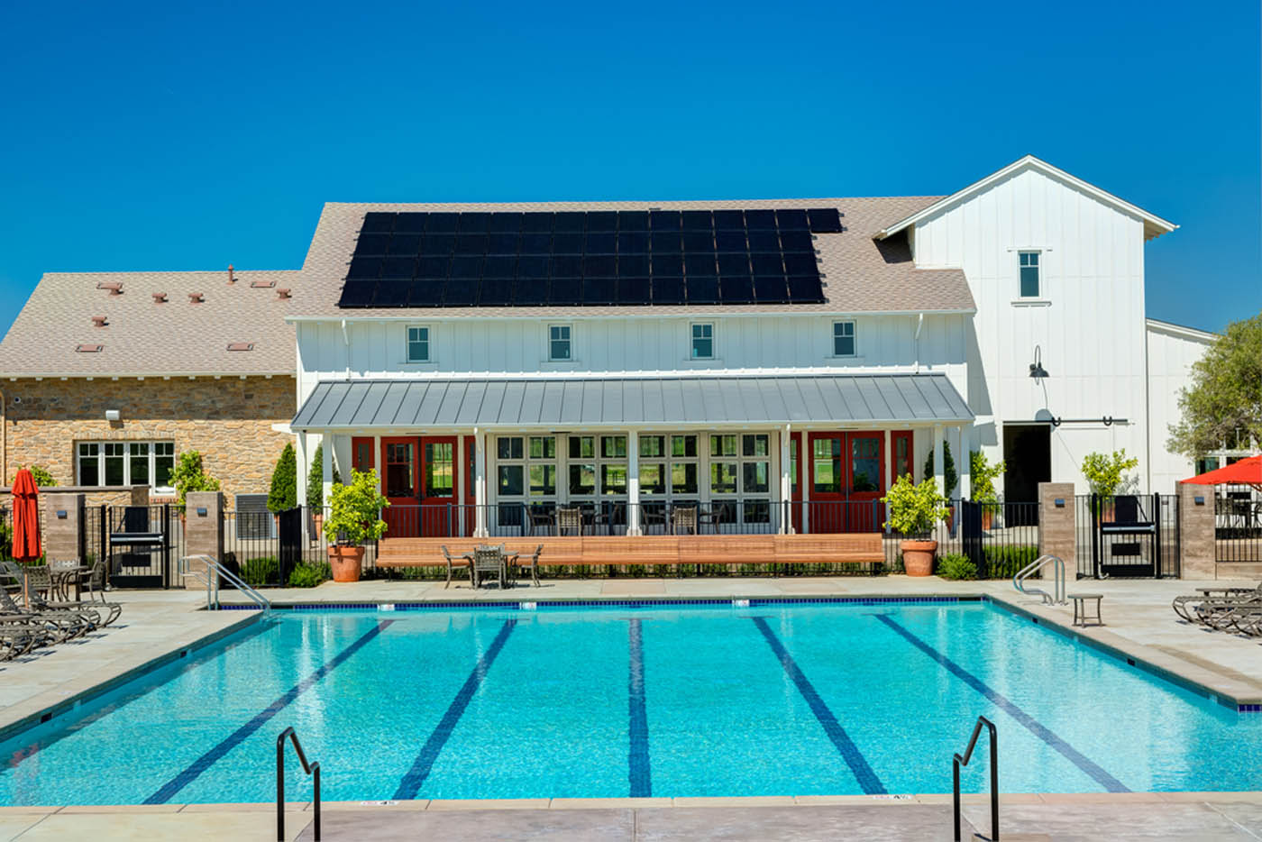 A grey house at dusk with lighting generating power from their solar panels.