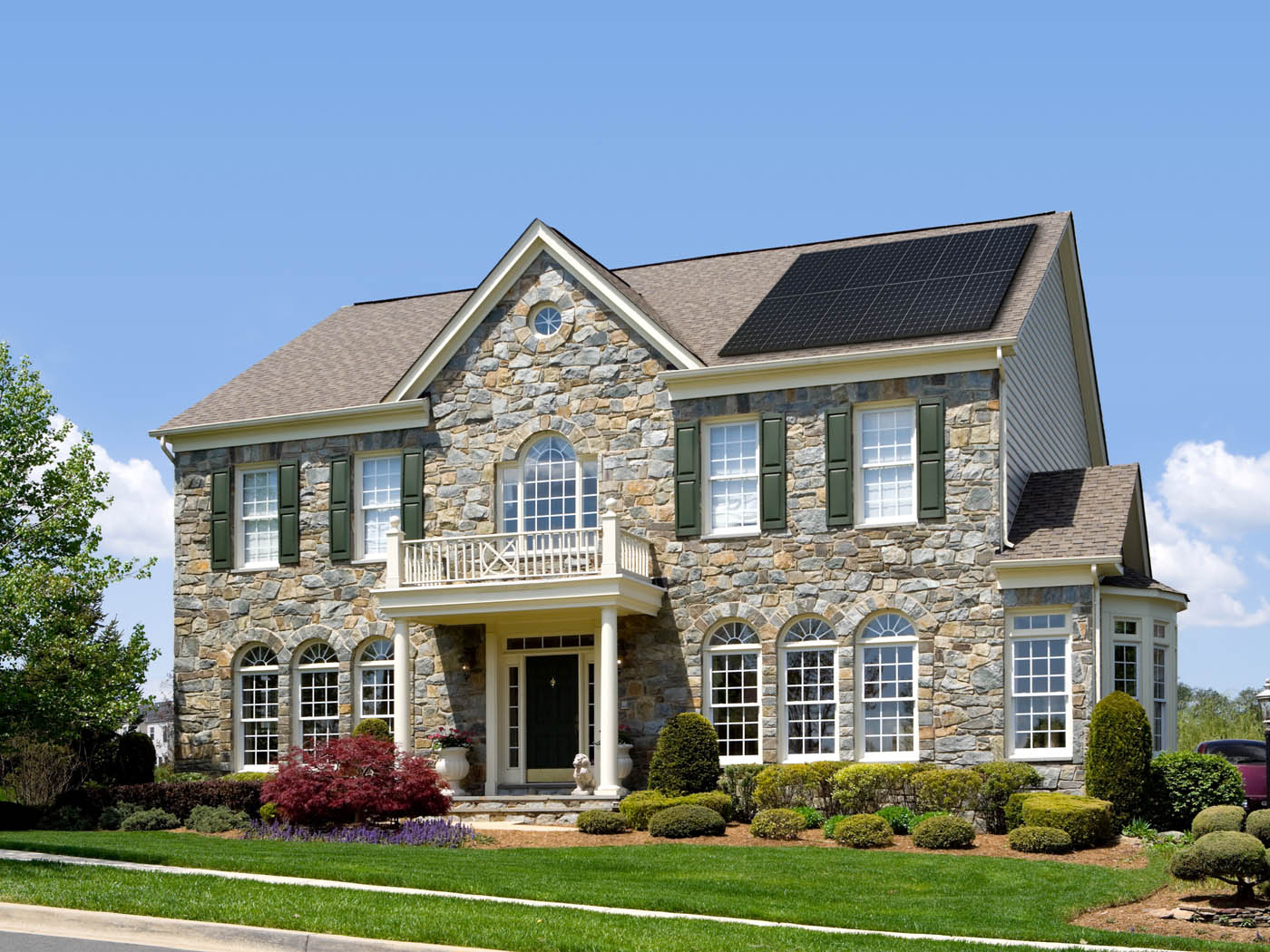 Large cobblestone house using SunPower solar panels.