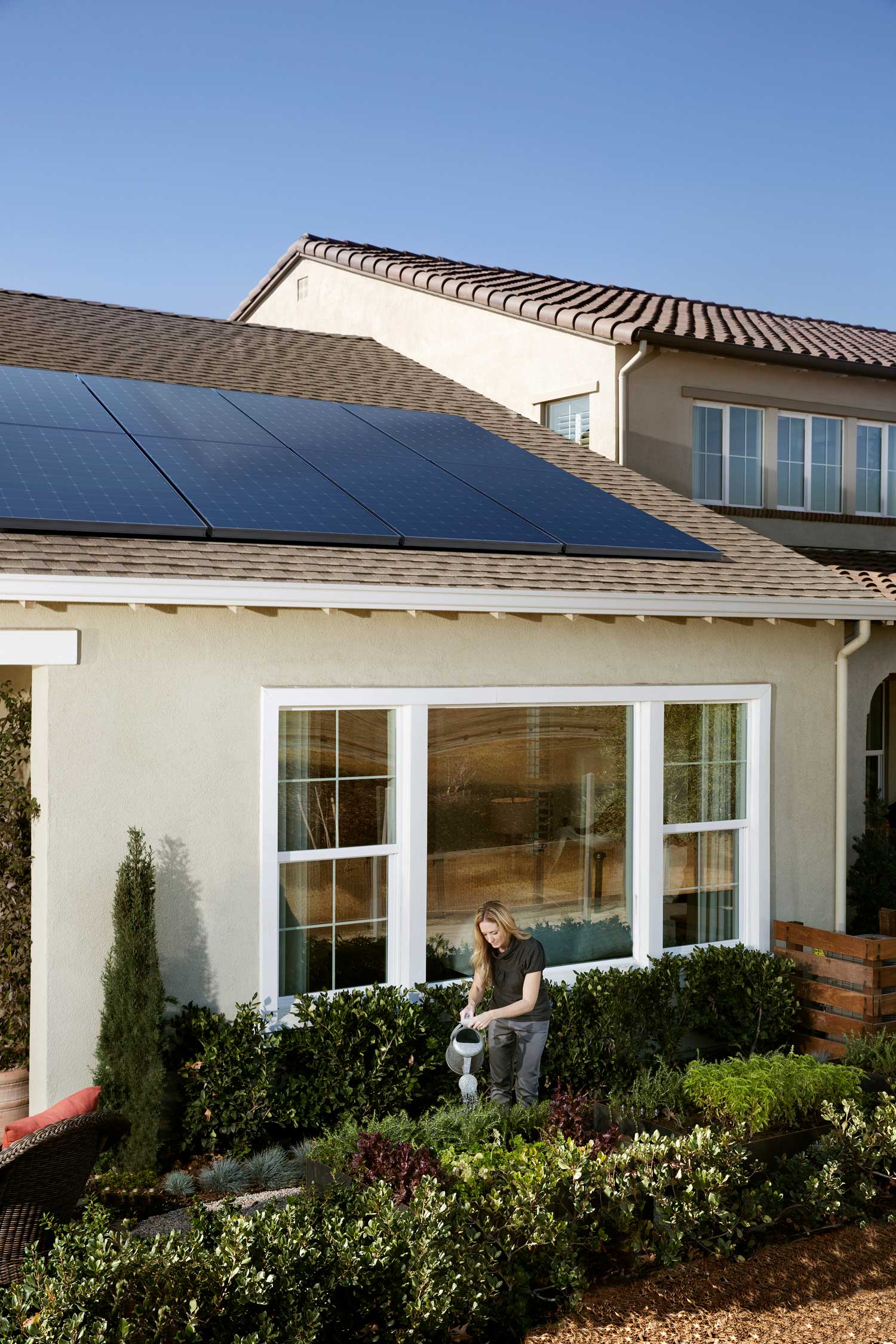 Solar Energy Partners solar installers in South Carolina & Georgia, a women gardening outside by her new solar panels.