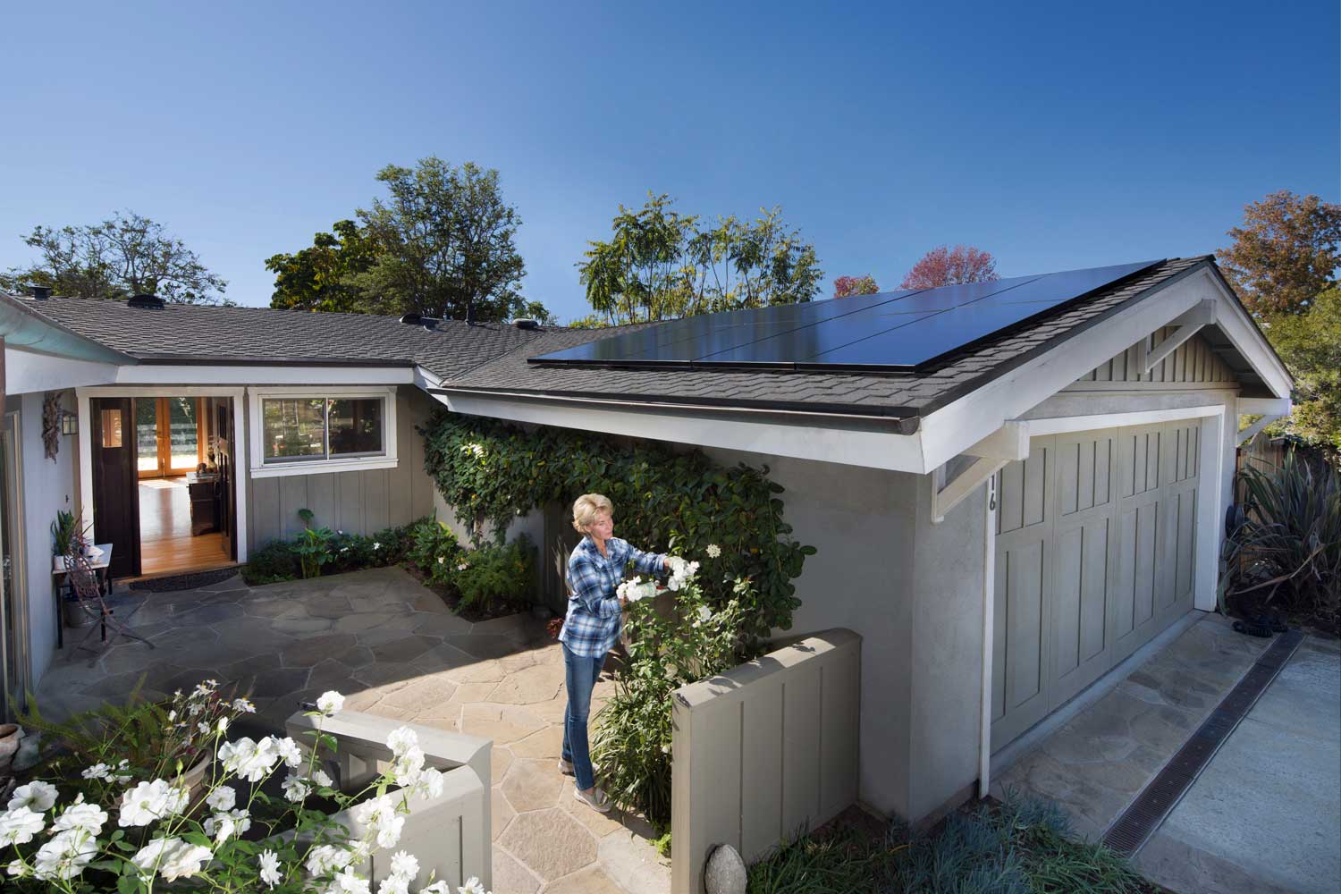 An older lady planting flowers in her home while enjoying the benefits of solar power. 